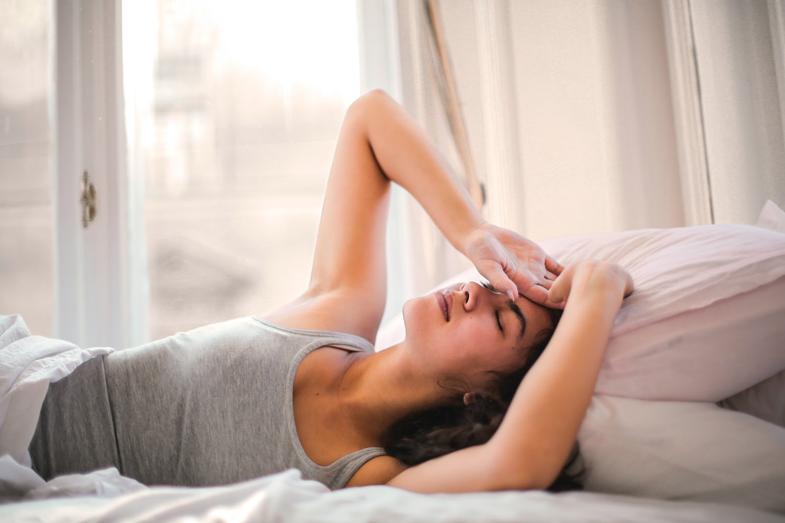 a woman is lying on the bed after waking up