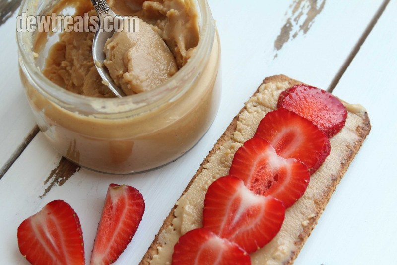 a slice of banana bread with peanut butter above and strawberry slices